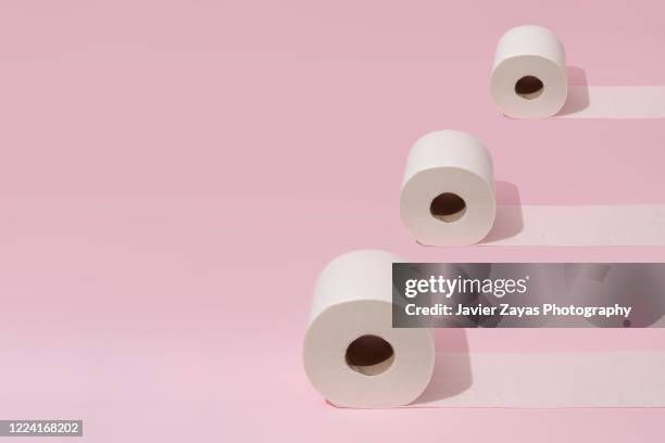 three toilet rolls on pink background - domestic bathroom - fotografias e filmes do acervo