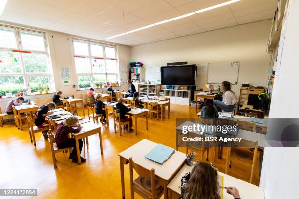 Teacher takes a class in a classroom at a Elementary school on May 11, 2020 in Duiven,Netherlands. Schools open their doors today and children can go...