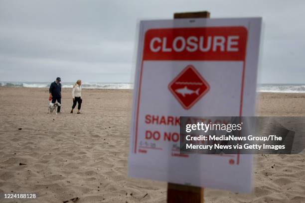 Terri Tucker walks with her husband Brent and their dog Lily along Sand Dollar Beach in Watsonville, Calif., where she had earlier witnessed a shark...