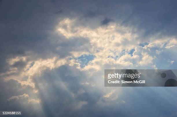 sunlight shining through a break in gray clouds - every cloud has a silver lining stock pictures, royalty-free photos & images