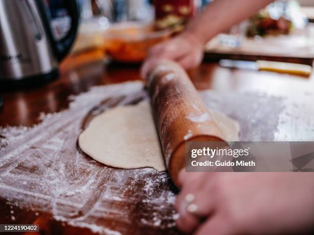 woman doing dough with rolling pin in kitchen. - rolling pin photos et images de collection