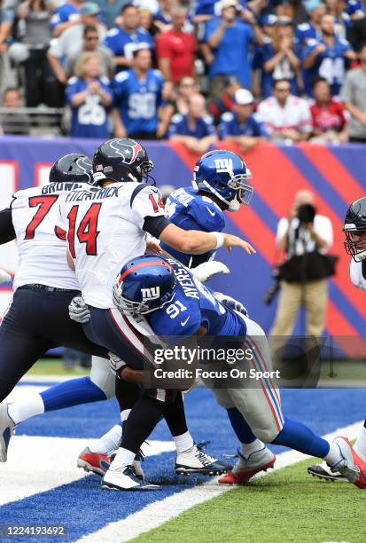 Robert Ayers of the New York Giants puts the pressure on quarterback Ryan Fitzpatrick the Houston Texans during an NFL football game September 21,...