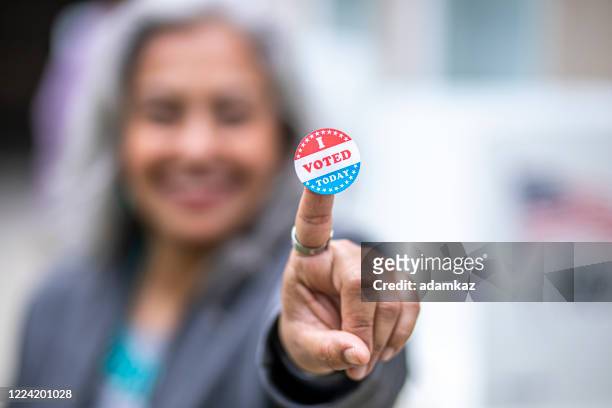 senior mexican woman with i voted sticker - women suffrage stock pictures, royalty-free photos & images