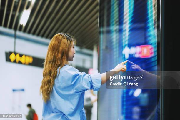 businesswoman using a large touch screen in the subway station - interactive stock-fotos und bilder