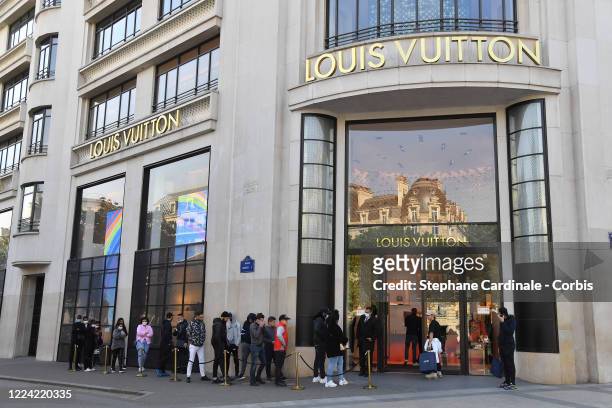 Clients are seen queueing up in front of the Louis Vuitton flagship store on avenue des Champs-Elysees on May 11, 2020 in Paris, France. France has...