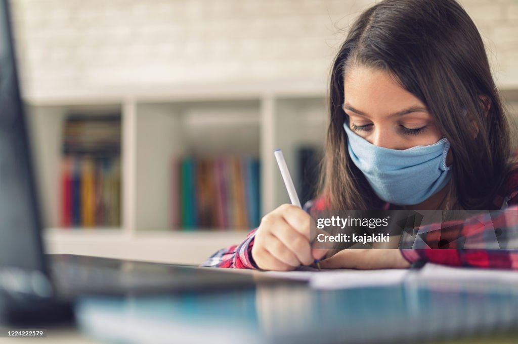 Teenage girl studying at home during COVID-19 pandemic