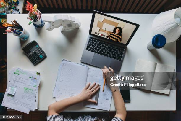 young girl studying at home with a laptop - homeschooling concept - high angle view - calculator top view stock pictures, royalty-free photos & images