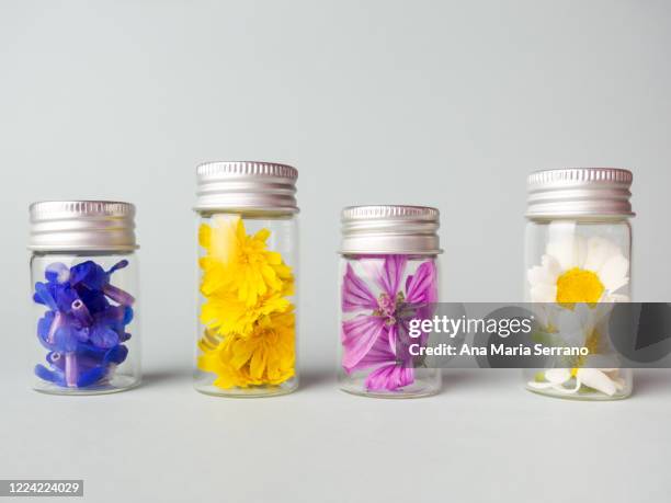 glass pots with flowers. homeopathy and natural medicine concept - bachblüten stock-fotos und bilder
