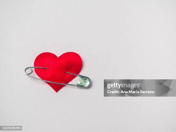 red heart with a safety pin. love concept - imperdible fotografías e imágenes de stock