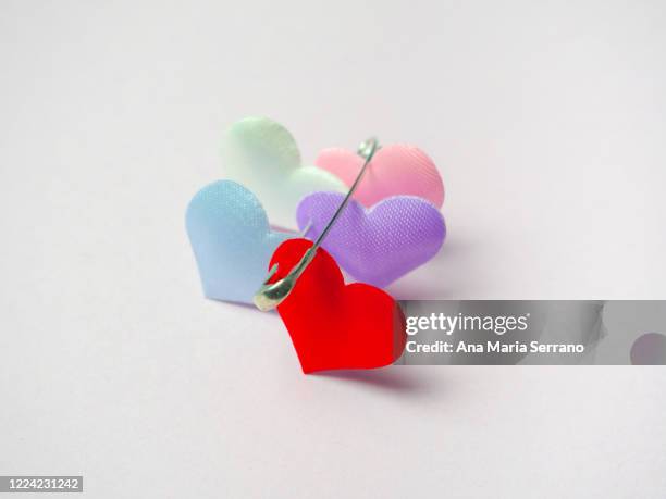 hearts attached with safety pin. polyamory concept - polyamory - fotografias e filmes do acervo