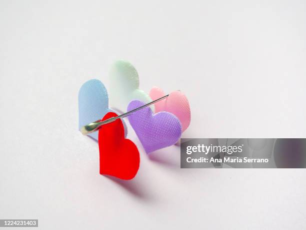 hearts attached with safety pin. polyamory concept - ポリアモリー ストックフォトと画像