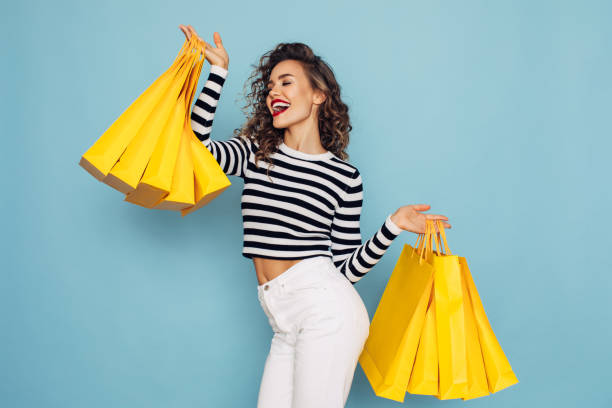 幸せな女の子の概念写真は、青い背景に買い物のパッケージを保持しています - sale ストックフォトと画像
