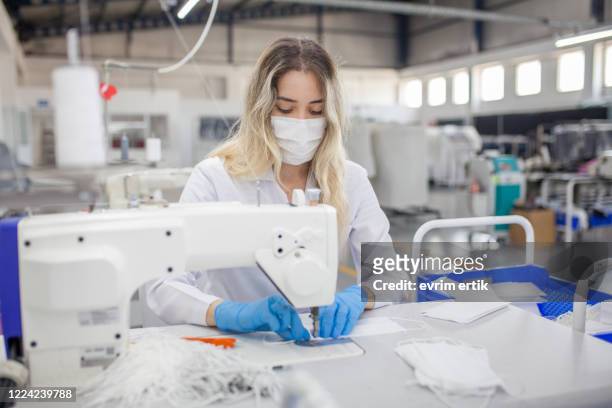 arbeiterin, die medizinische maske auf einer nähmaschine - cloth mask stock-fotos und bilder