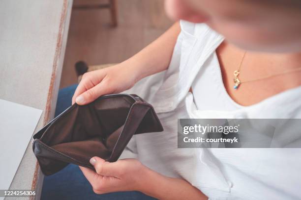 mujer abriendo una billetera vacía. - bolso abierto fotografías e imágenes de stock