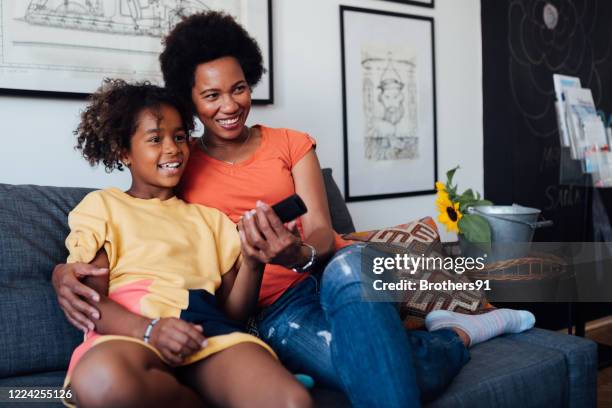 madre con la figlia a casa, guardando la tv - african watching tv foto e immagini stock