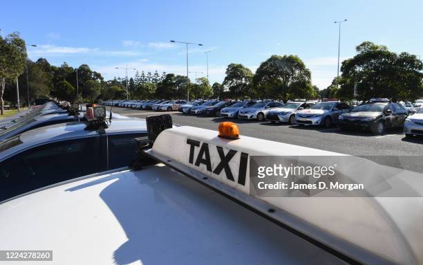 Lines of de-registered taxis with number plates removed sit in a council car park in the suburb of Tempe near Sydney Airport on May 12, 2020 in...