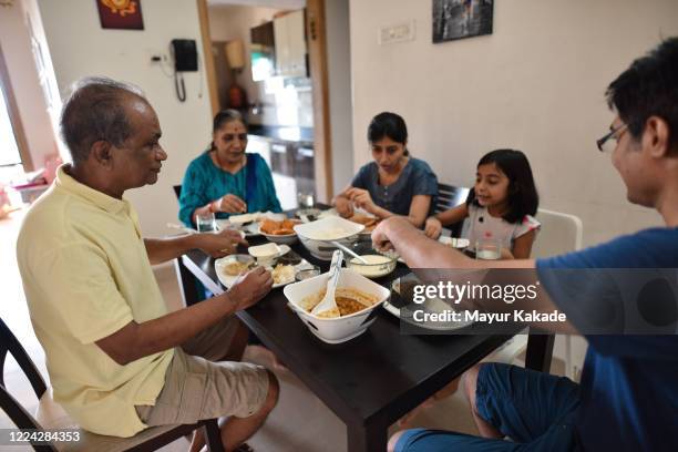 milti generation family having meal together - indian family dinner table stock pictures, royalty-free photos & images