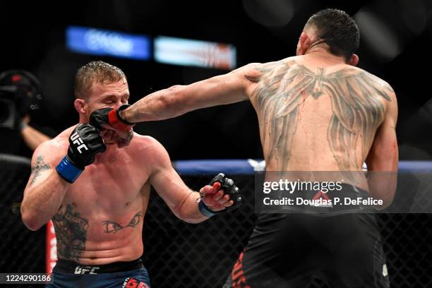 Tony Ferguson of the United States punches Justin Gaethje of the United States in their Interim lightweight title fight during UFC 249 at VyStar...