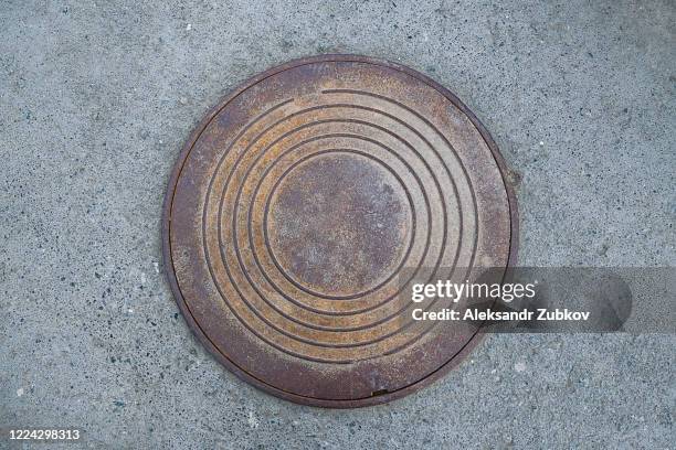 iron sewer manhole on the city asphalt road. - マンホール ストックフォトと画像