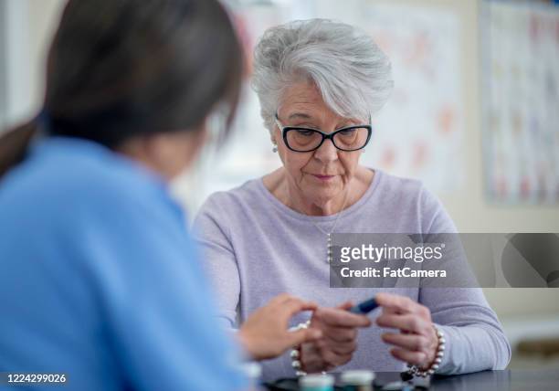 senior adult at medical appointment - dementia test stock pictures, royalty-free photos & images