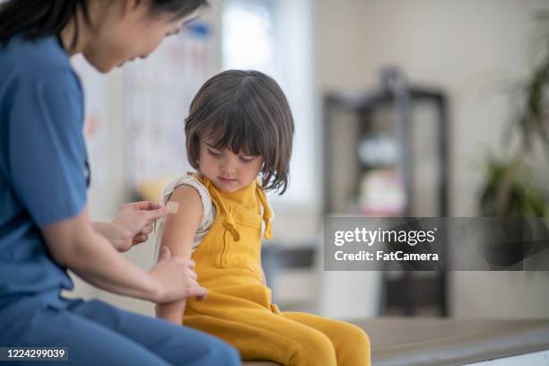 little girl after immunization - child vaccination stock pictures, royalty-free photos & images