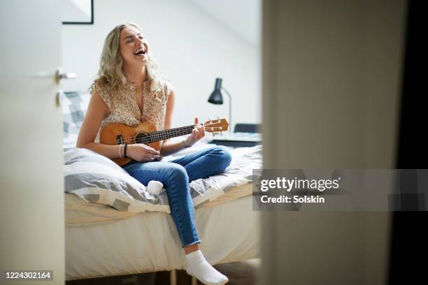 teenage girl playing ukulele in her room - music room stock pictures, royalty-free photos & images