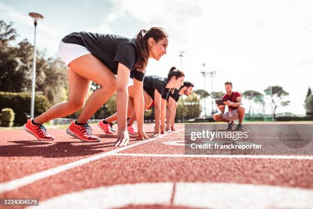 athlètes lisant pour commencer sur la piste - femme sportive photos et images de collection