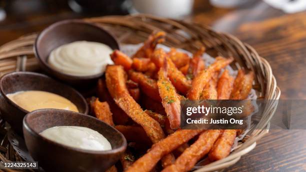 sweet potato french fries, condiments - zoete aardappel stockfoto's en -beelden