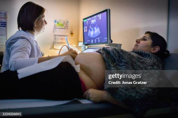 Doctor examines Anjelika Daneliani's stomach with ultrasound. Anjelika Daneliani is a surrogate mother and carries a Spanish couple's baby in her...