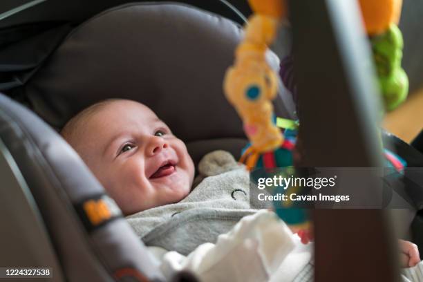 high angle view of smiling baby in car seat - baby products stock pictures, royalty-free photos & images