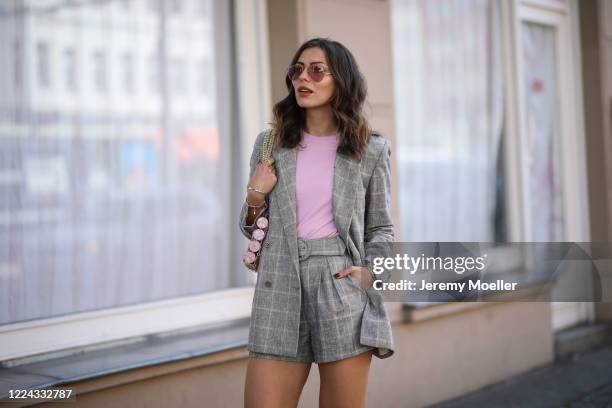 Masha Sedgwick wearing Ray Ban shades, Envii shirt and Sandro shorts, jacket and bag on May 06, 2020 in Berlin, Germany.