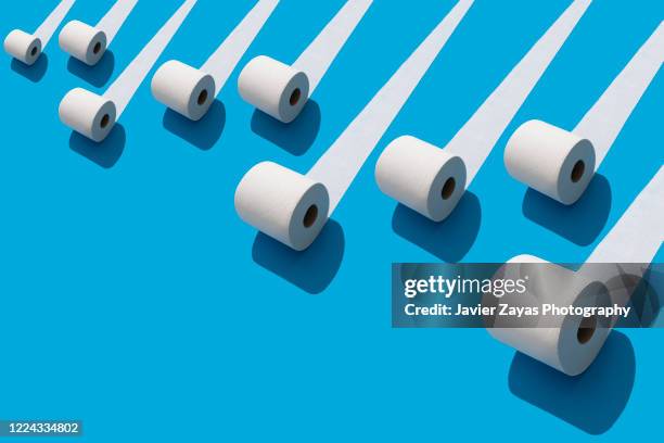 many toilet rolls on blue background - diarrhö stock-fotos und bilder