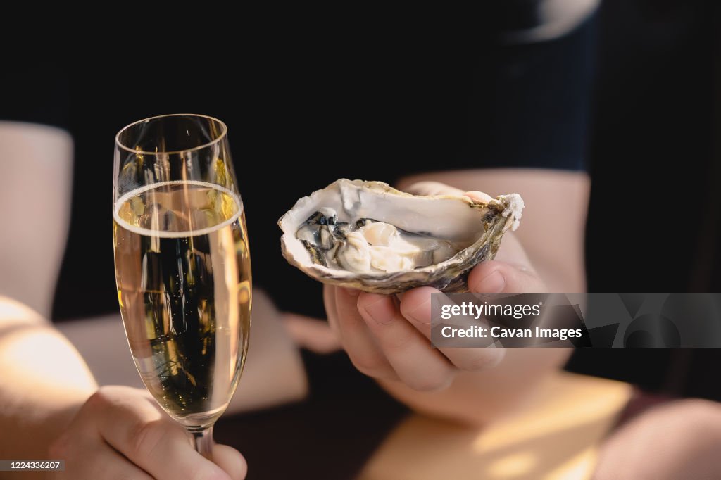 An oyster and a glass of champagne in the hand