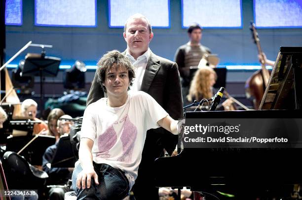 English singer and pianist Jamie Cullum seated on stage with Marc Connor and an orchestra during the Proms at the Royal Albert Hall in London on 26th...