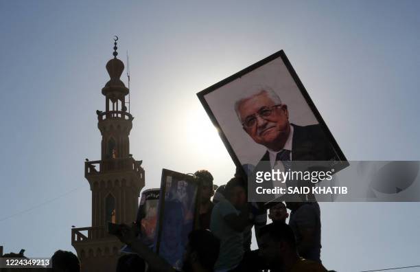 Protesters hold a portrait of Palestinian President Mahmud Abbas during a demonstration against Israel's West Bank annexation plans, in Khan Yunis in...