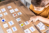 Little kid playing with cards of words and pictures.