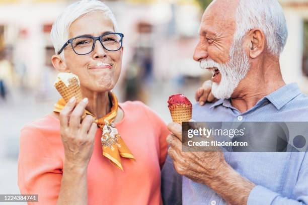 happy senior couple eating ice cream - ice cream sunday stock pictures, royalty-free photos & images
