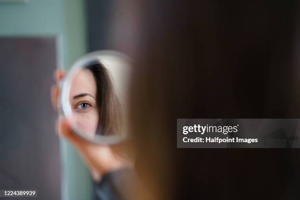woman looking at herself in mirror. - spiegel stockfoto's en -beelden