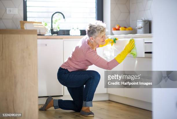front view of senior woman indoors at home, cleaning kitchen. - housework stock pictures, royalty-free photos & images