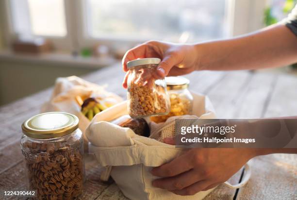 unrecognizable woman standing indoors, unpacking zero waste shopping. - food staple stock pictures, royalty-free photos & images