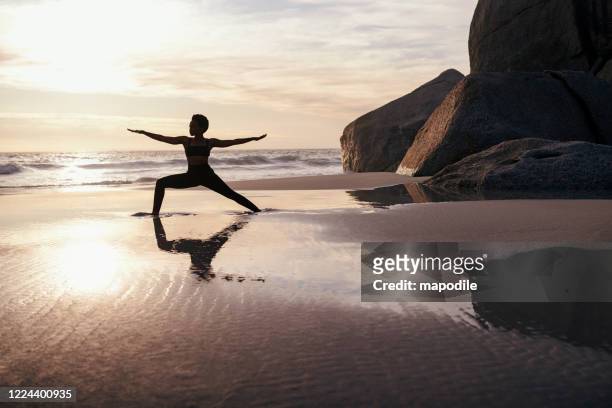 yoga treibt sie geistig und körperlich gleichzeitig - woman stretching sunset stock-fotos und bilder