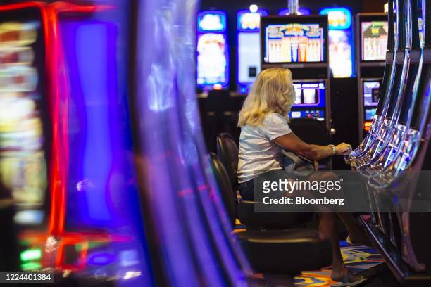 Visitor wears a protective mask while playing a slot machine at the Ocean Casino Resort in Atlantic City, New Jersey, U.S., on Thursday, July 2,...