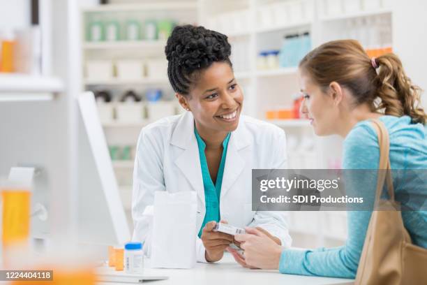 pharmacist consults with female patient - pharmacist explaining stock pictures, royalty-free photos & images