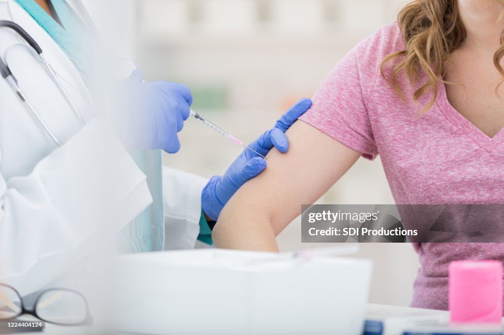 Unrecognizable woman receives flu shot