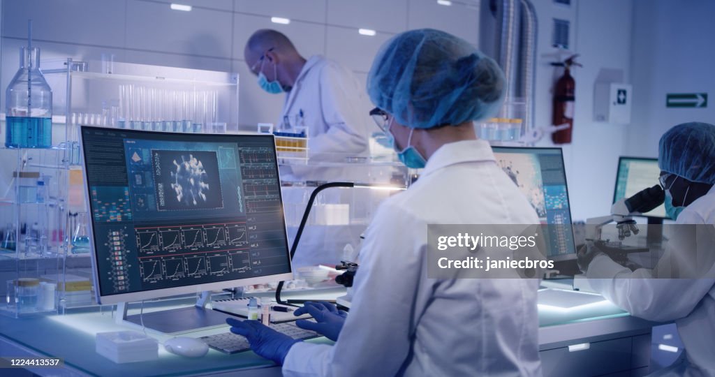 COVID-19 - laboratory team working on coronavirus vaccine. Protective workwear