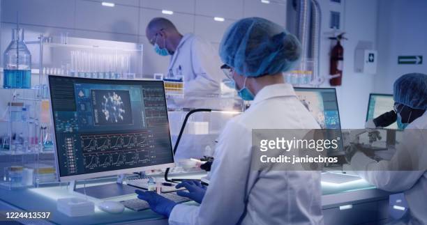 covid-19 - laboratory team working on coronavirus vaccine. protective workwear - covid 19 stock pictures, royalty-free photos & images