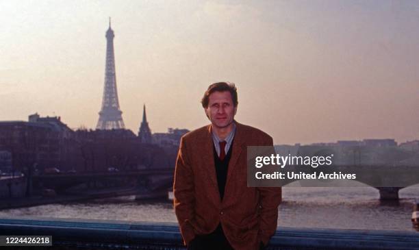 German journalist Ulrich Wickert on a bridge over river Seine with Eiffel tower in the background as editor in chief of WDR Paris studio, France 1991.