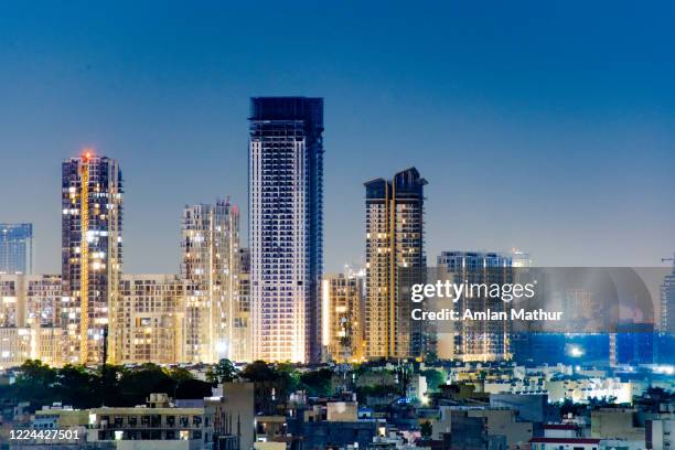 aerial night shot of buildings with homes and offices with more skyscrapers in the distance in gurgaon noida - delhi fotografías e imágenes de stock