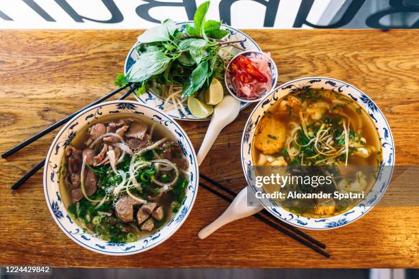 lunch at vietnamese restaurant with pho soup in a bowl, directly above view - pho suppe stock-fotos und bilder