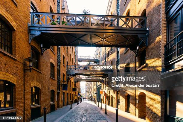 shad thames street lit with sunlight at sunset, london, uk - central london stock pictures, royalty-free photos & images